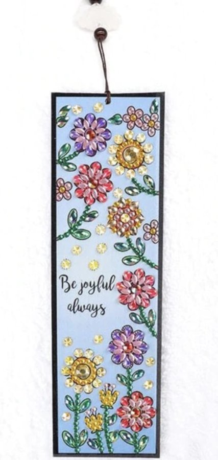 Diamond painting bookmark with colorful flowers and the text "Be joyful always", with a white tassel.