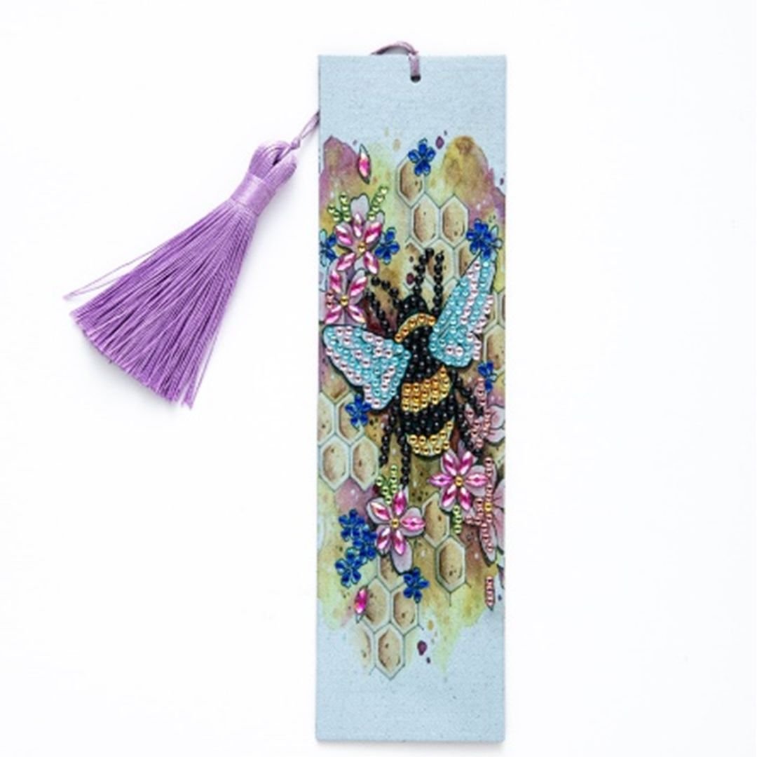 Diamond painting bookmark with a sparkling bee, flowers, honeycomb pattern, and a purple tassel.
