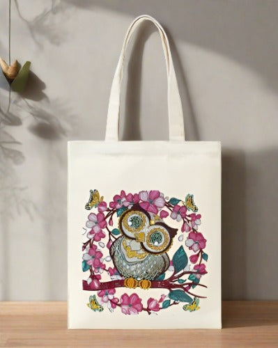 Canvas bag with a diy diamond art application of a owl sitting on branch with pink and white flowers and butterflies 