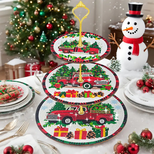  A completed three-tiered Christmas display tray with a gold handle. Each tier is decorated with a diamond-painted red vintage truck carrying a Christmas tree and gifts.