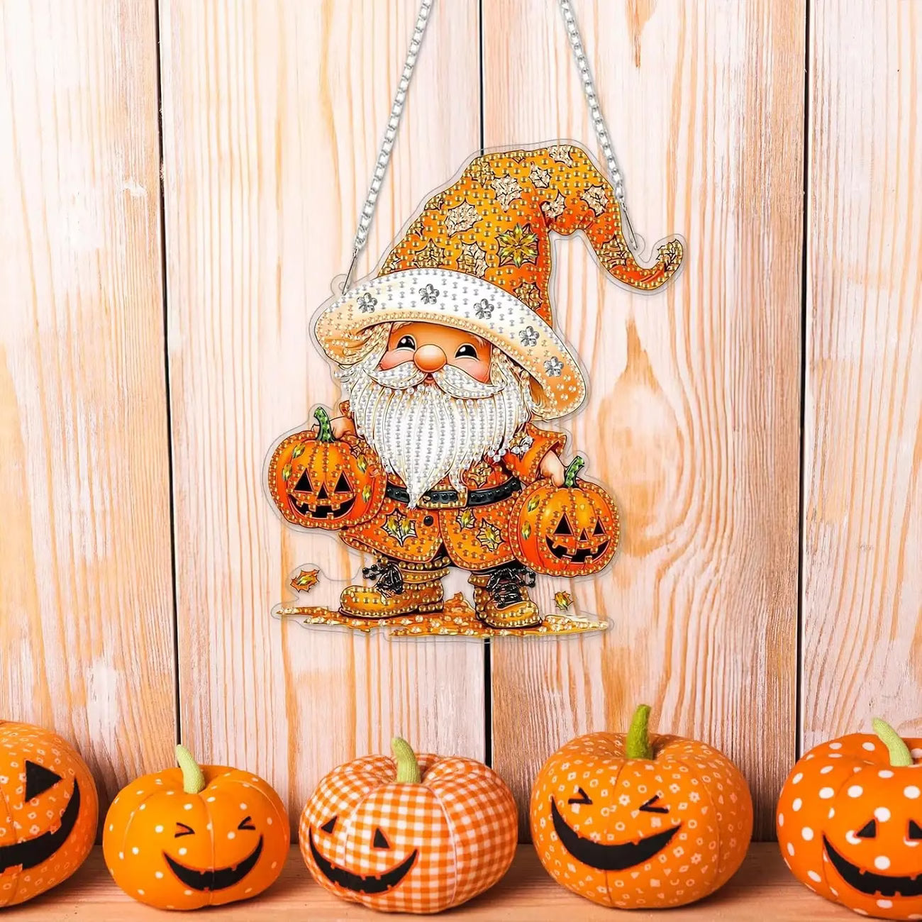 Decorative Halloween gnome with pumpkins on a wooden background