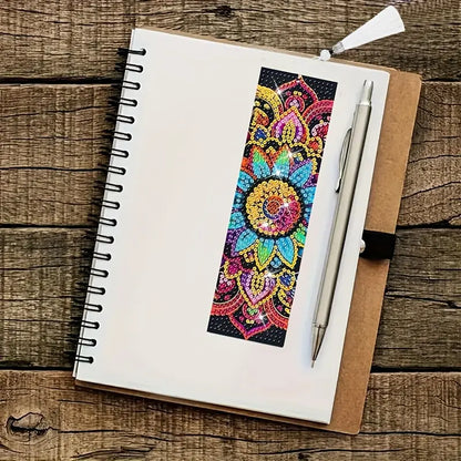 Notebook with a colorful mandala bookmark and pen on a wooden surface