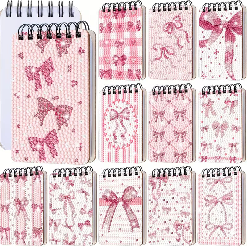 Set of small notebooks with pink bow and patterned designs on a white background
