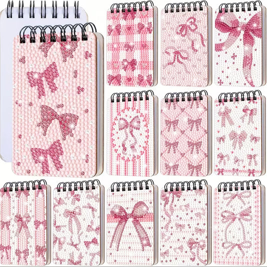 Set of small notebooks with pink bow and patterned designs on a white background