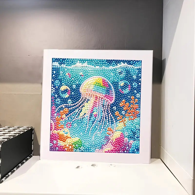 Framed diamond painting kit of a colorful jellyfish underwater scene on a gray wall.