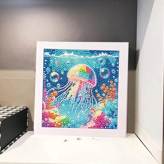 Framed diamond painting kit of a colorful jellyfish underwater scene on a gray wall.