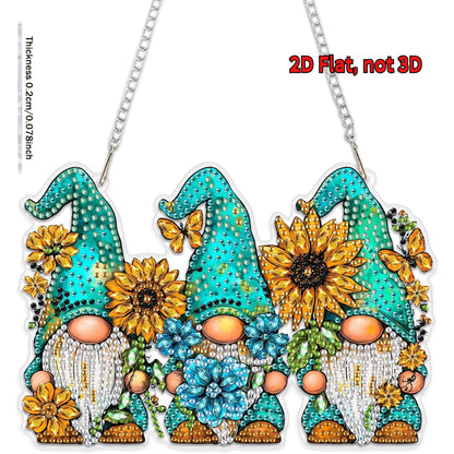 A completed 2D flat acrylic diamond-painted sun catcher featuring three gnomes with teal hats surrounded by yellow sunflowers and blue blossoms.