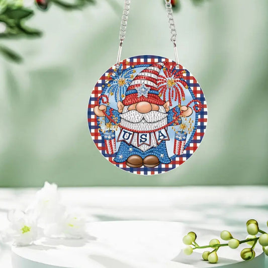 A round, multicolored diamond art pendant featuring an acrylic gnome with a USA sign and red, white, and blue fireworks design, completed and hanging from a chain.