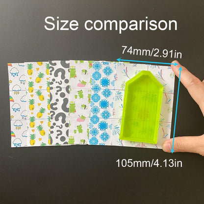 Size comparison of a green plastic tool with a patterned cover paper for diamond painting